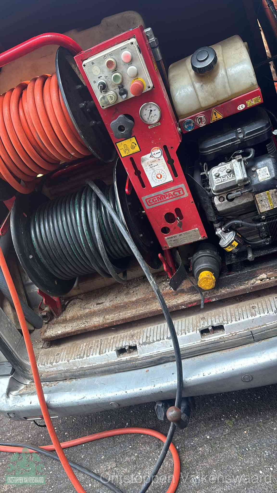 Een rood hogedruk-rioolreinigingstoestel in de laadbak van de bedrijfsbus, apparatuur voor een hardnekkige afvoerverstopping in Valkenswaard