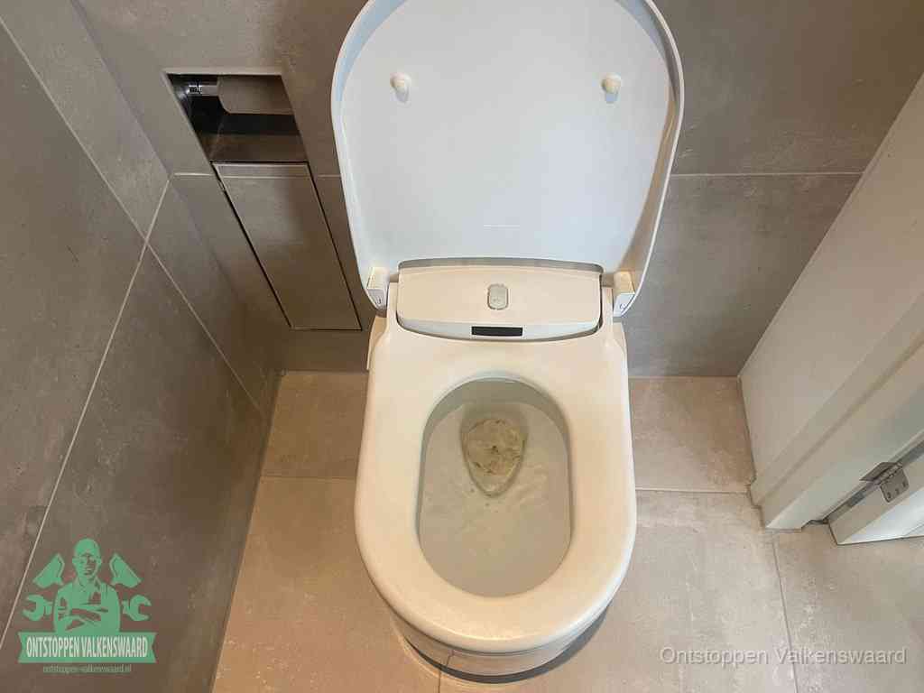Een wit hangtoilet waarin een prop wc-papier op het water blijft drijven, een duidelijk signaal van een verstopte wc in Valkenswaard