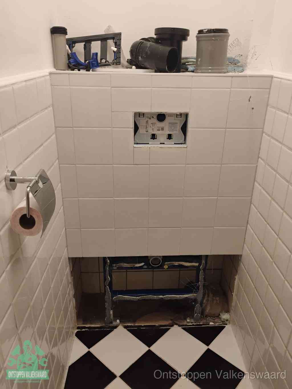 Een toiletruimte waar het hangtoilet en de inbouwreservoir-onderdelen zijn vrijgelegd voor onderhoud, periodiek nazicht voorkomt een wc-verstopping in Valkenswaard